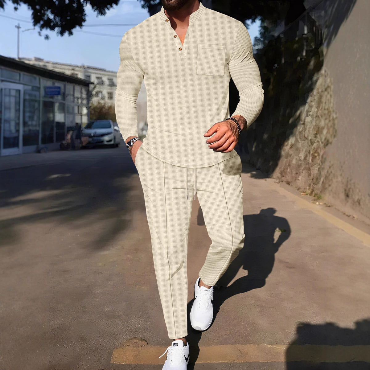 Man in a beige outfit walking on a street
