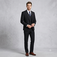 Man wearing a black suit with a white shirt and brown shoes on a gray background