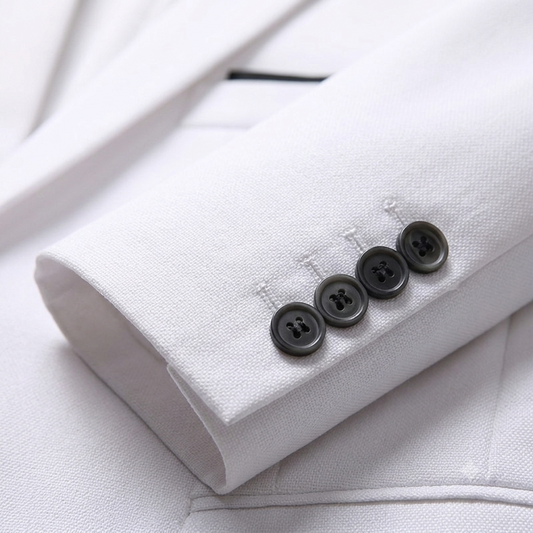 Close-up of a white suit jacket with black buttons on a light gray background
