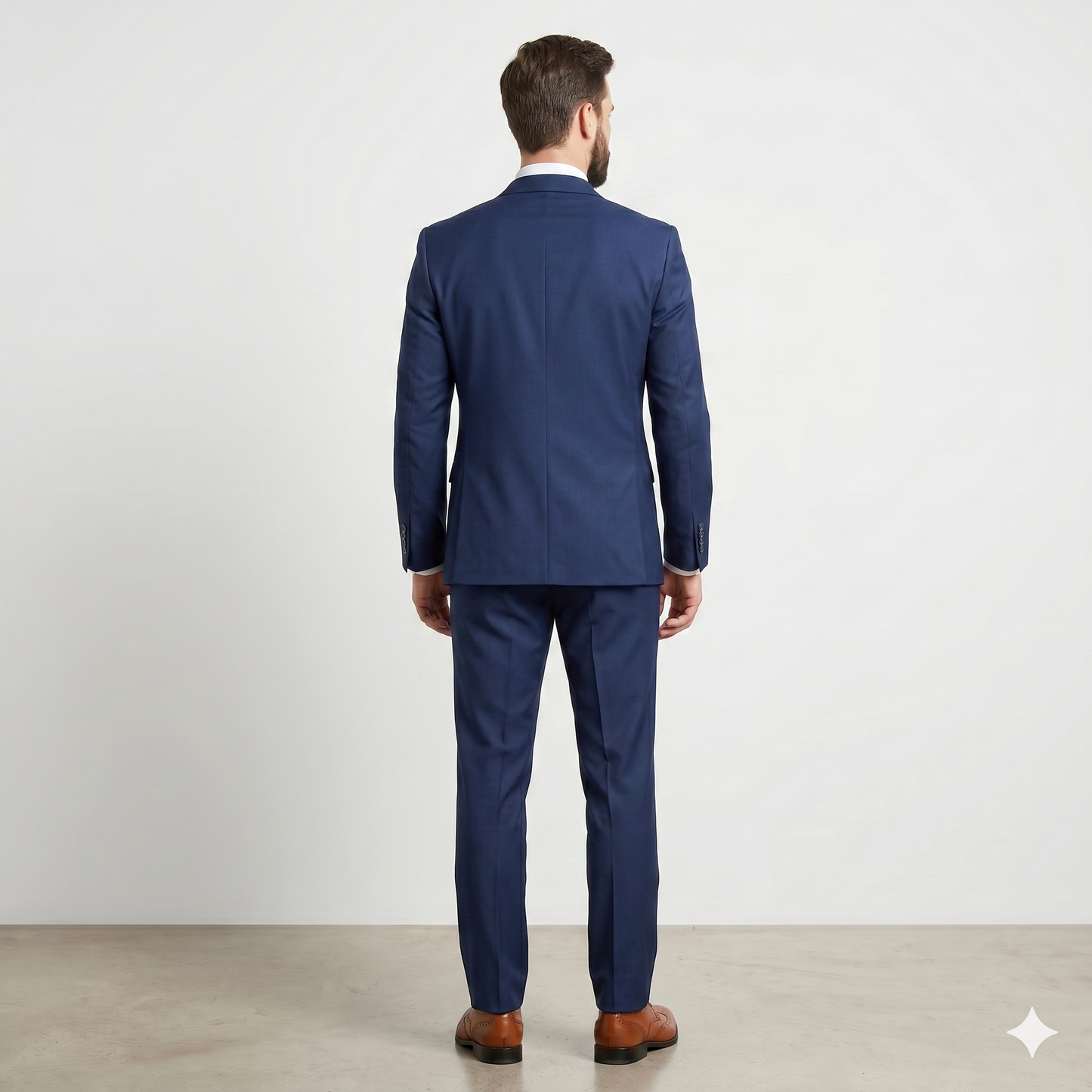 Man wearing a blue suit standing against a white background