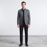 Man wearing a gray blazer and black pants on a light gray background