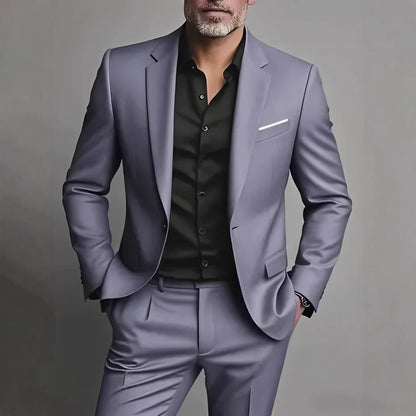 Man wearing a gray suit with a black shirt on a gray background