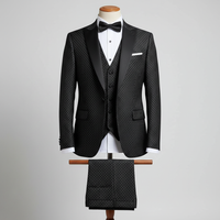 Three-piece black men’s tuxedo displayed upright on a wooden stand. Slim-fit jacket with black satin lapels and white dot embellishments evenly spaced across the fabric, layered over a matching waistcoat, with coordinated trousers folded neatly over the display bar. Styled with a white dress shirt and black bow tie. Clean studio background with soft, even lighting. 250:250
