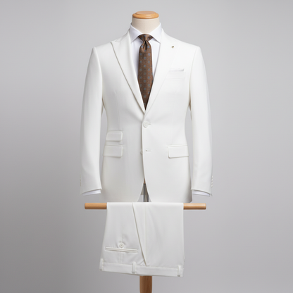 Two-piece vibrant white men’s suit displayed upright on a wooden stand. Slim-fit jacket with clean tailoring and structured shoulders, paired with matching trousers folded neatly over the display bar. Styled with a white dress shirt, brown patterned tie, and white pocket square. Set in a clean studio background with soft, even lighting. ratio: 250 x 250 